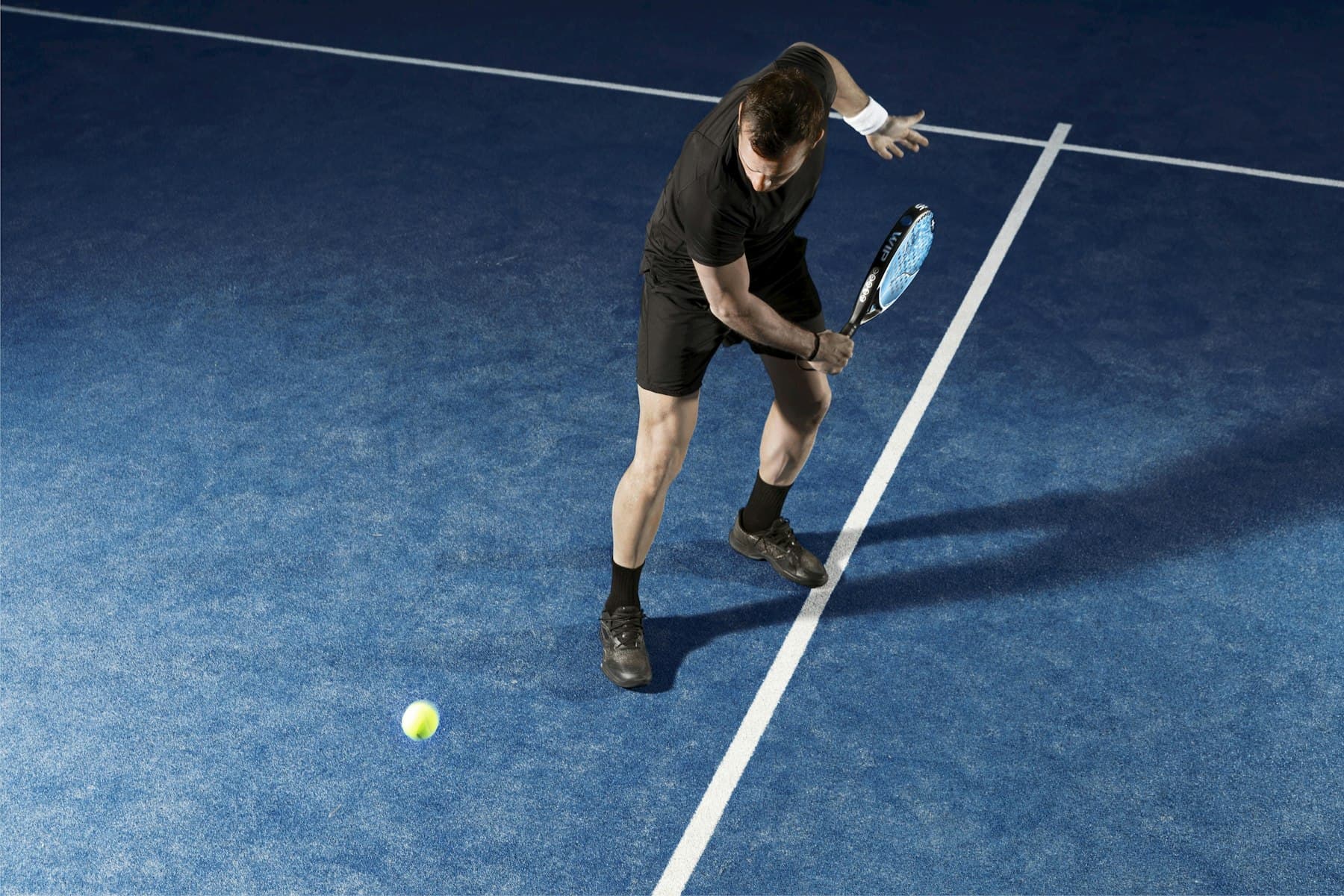 Giocatore di padel su campo blu